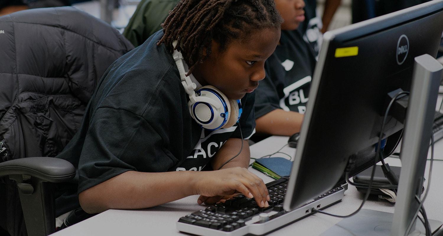 Black youths looking at computer screen